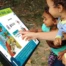 Toddler pointing at a sign with a story on it.