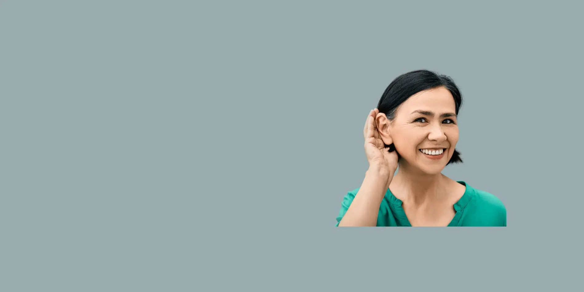 A woman cupping her hand to her ear.
