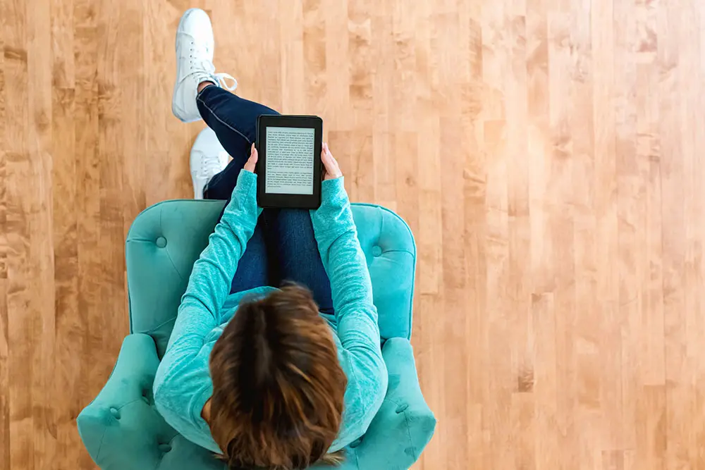 Overhead view of a seated woman reading an eBook.