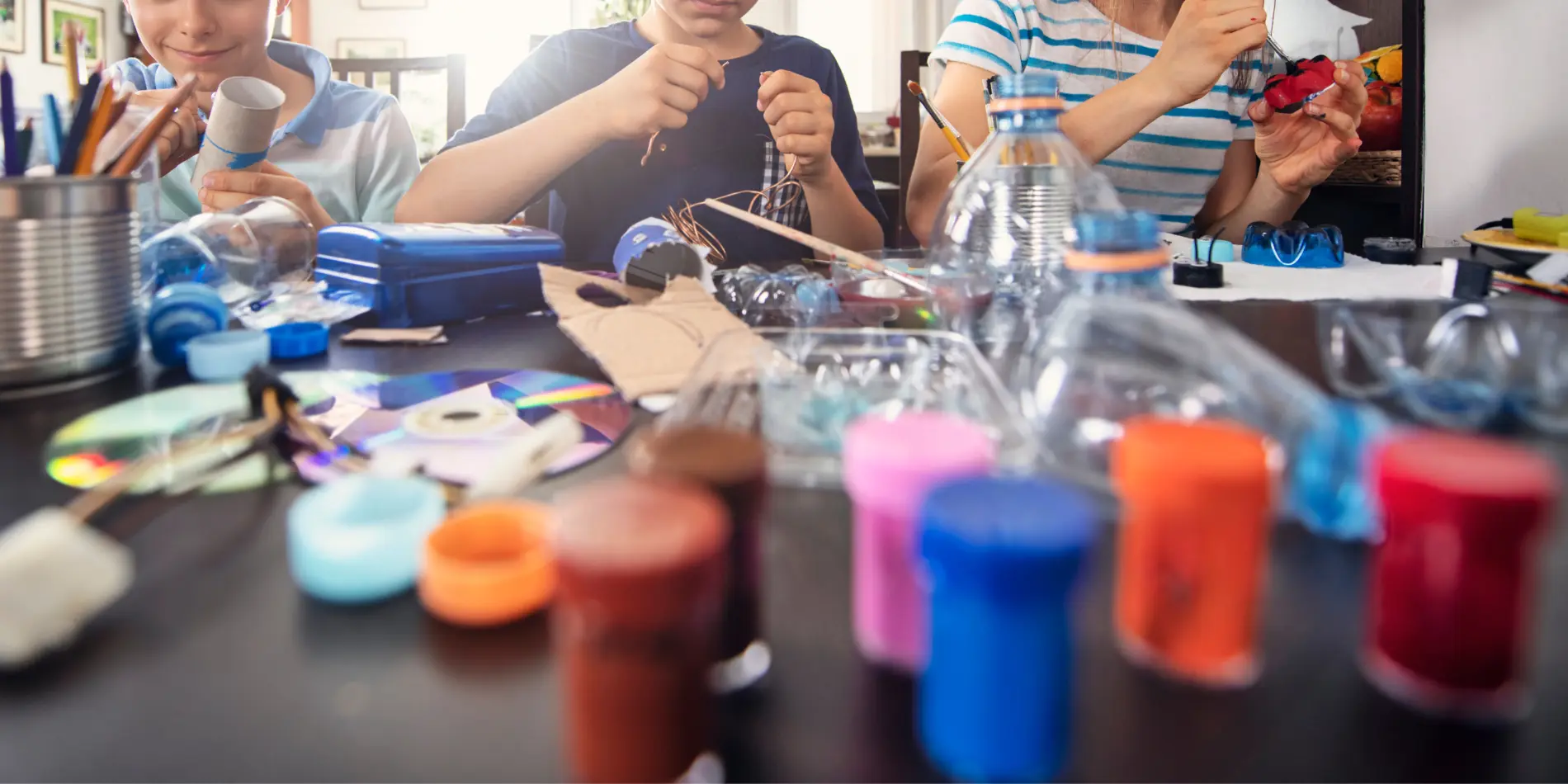 School-Holiday-Activities Three children with a table full of craft materials.