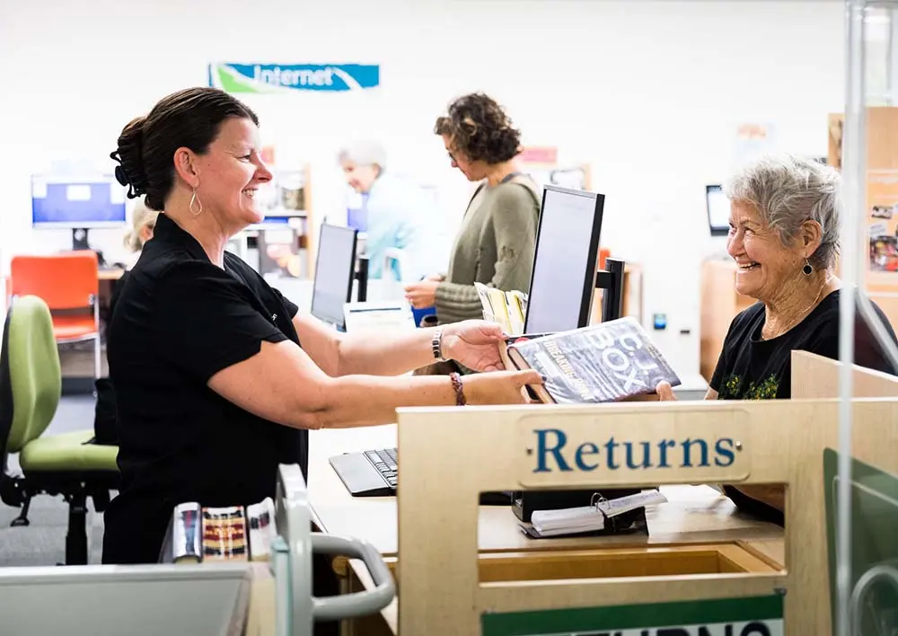 A librarian assisting a library patron.