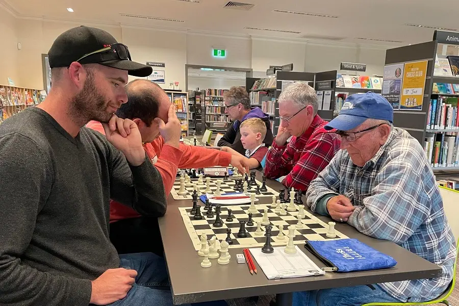 Six people, each playing a game of Chess.