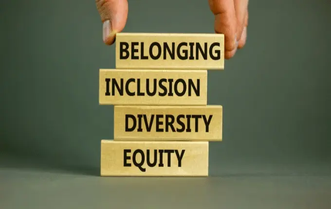 A hand laying blocks reading: equity, diversity, inclusion, and belonging.