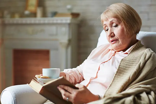 An older woman reading a book.