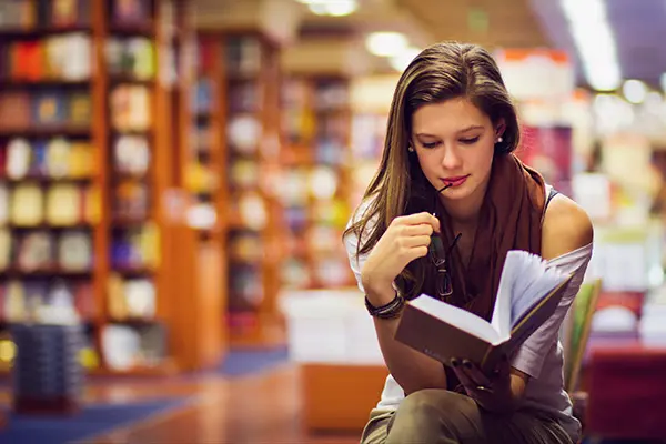 Seated woman reading a book.