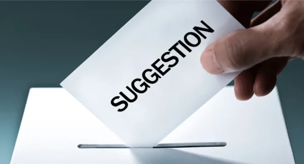 suggestion A card with the word suggestion on it being placed in a box.
