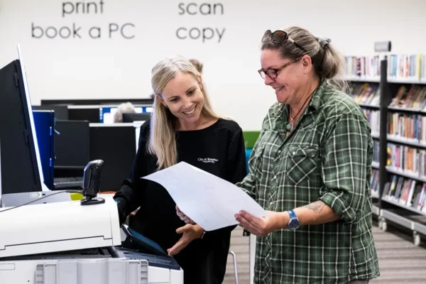 A librarian assisting a customer with photocopying.