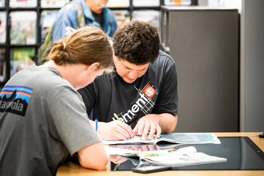 Two people studying together in the library.