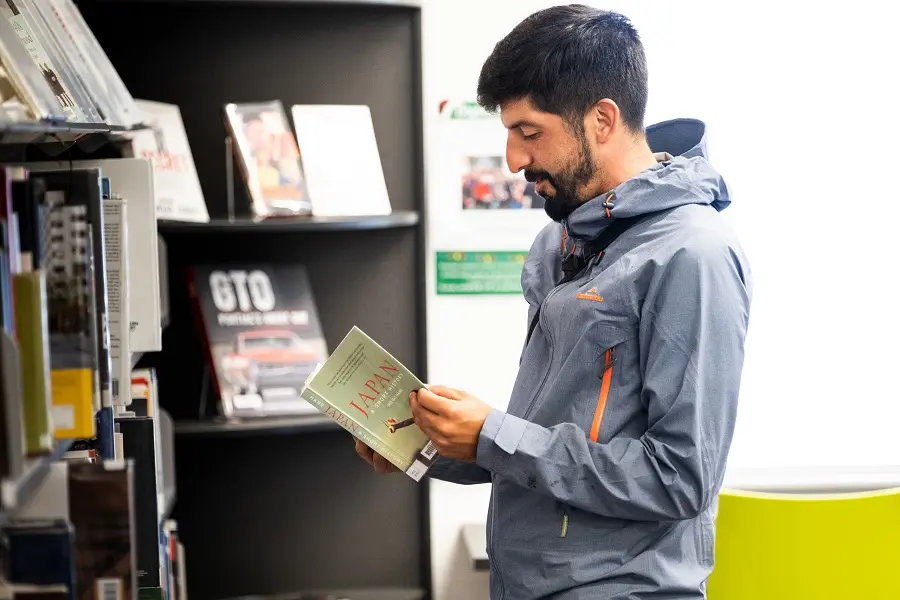 A librarian explaining a flier to a library patron.