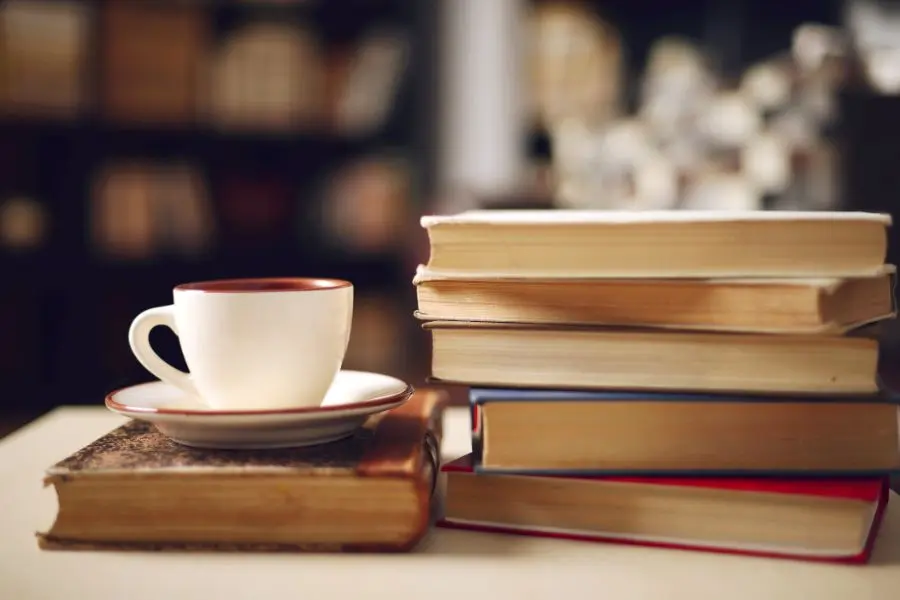 Two piles of books, with a cup and saucer placed on top of one.