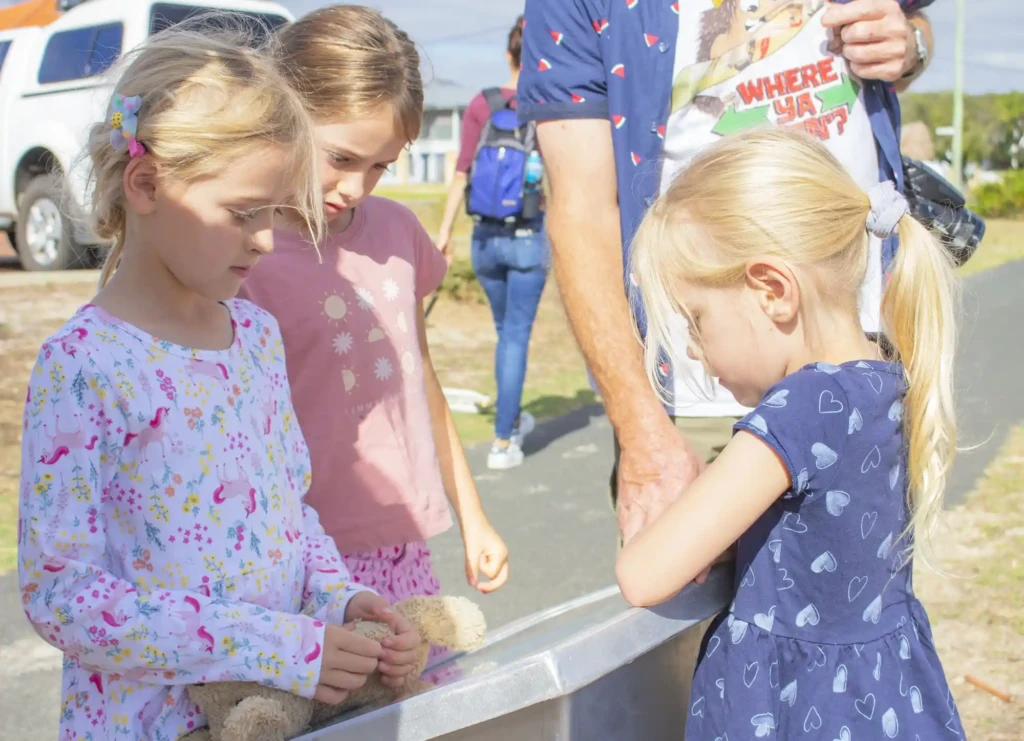 Two children standing at a plinth along The Storytime Way.