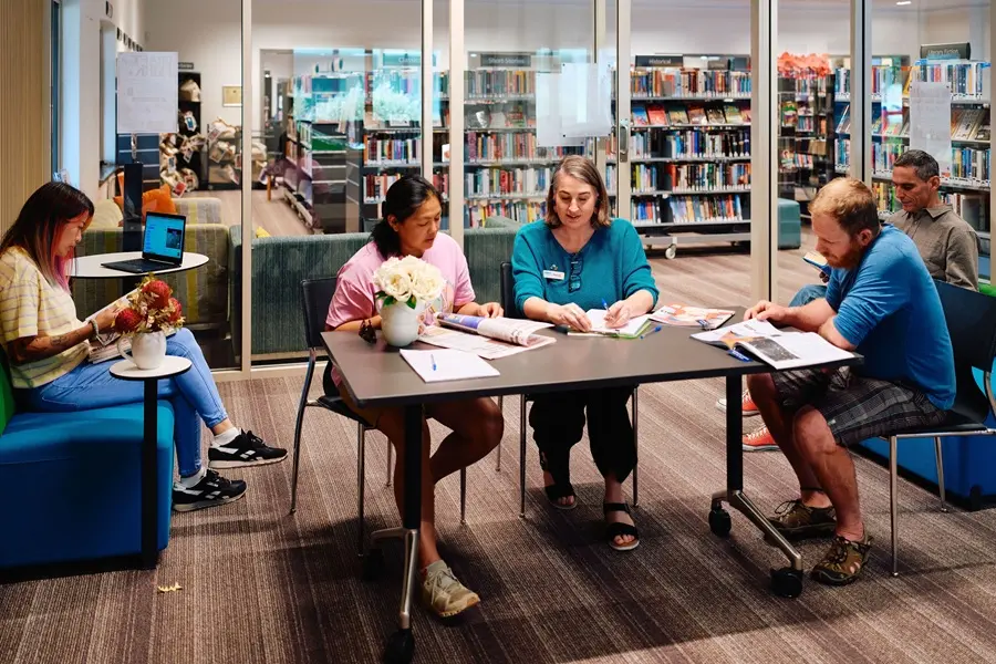 book-chat-club-2026 A group of people sitting in the library together, all reading different things.