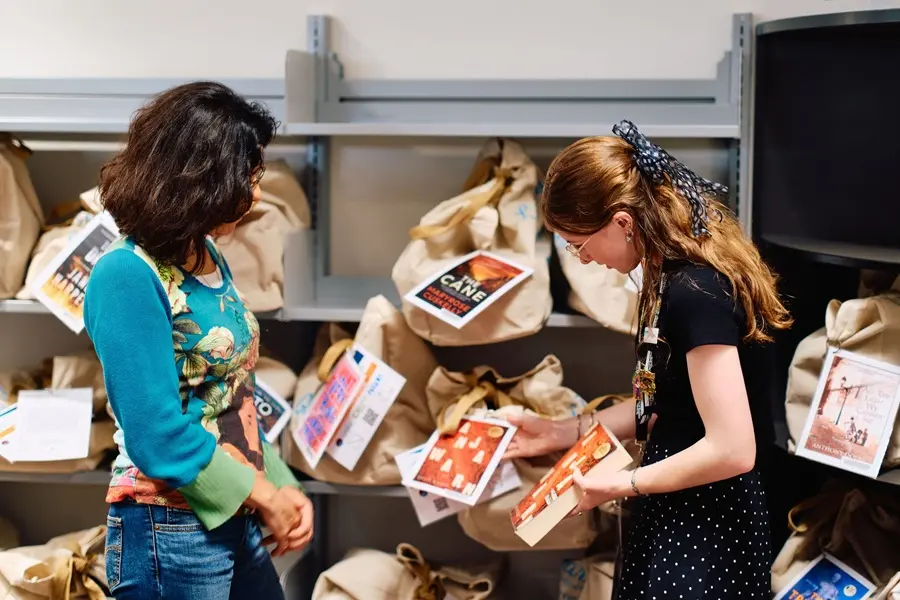 A librarian assisting a customer to select a book club set.